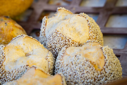 A batch of lye bread rolls coated in sesame seeds