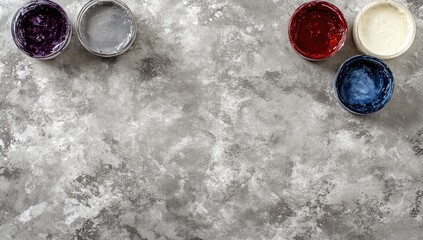 Colorful paint containers arranged on a textured gray surface