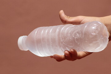 Hand holding a bottle of frozen water