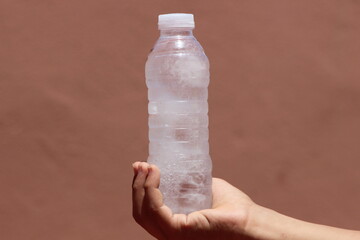 Hand holding a bottle of frozen water