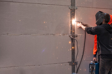 Tradesman welding fencing in a home environment