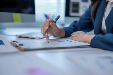 A woman is writing on a piece of paper with a pen