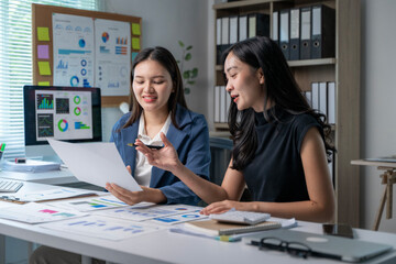 Obraz premium Two women are sitting at a desk with a white board behind them