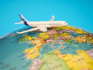 Obraz premium White airplane on a globe against a blue background