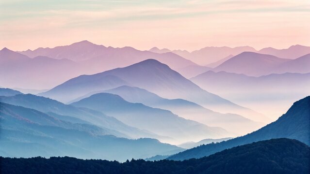 Layers of blue and purple mountains are shrouded in fog at dusk
