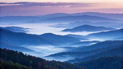 Obraz premium A panoramic view of misty mountains at sunrise reveals a serene and breathtaking landscape
