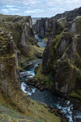 Panoramic View of Fjaðrárgljúfur Canyon with a Winding River and Towering Moss-Covered Cliffs, A Breathtaking Icelandic Landscape