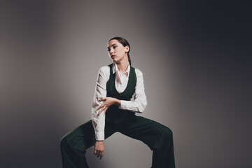 Stunning Professional Businesswoman Posing in Stylish Green Suit on Studio Grey Background