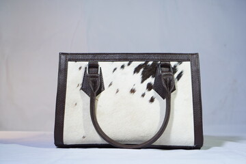 Cowhide and leather handbag with unique spot pattern, perfect for adding flair.