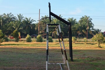 Fototapeta premium Outdoor sports field with basketball hoop and smaller goal in tropical setting under clear sky