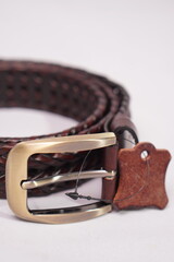 Stylish braided dark brown leather belt with a rustic brass buckle, a versatile accessory.