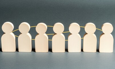 Row of light beige wooden figures connected by golden threads