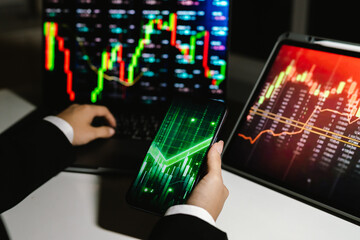 A trader analyzes real-time financial data on multiple devices, tracking stock charts, market trends, and investment strategies to manage risk, maximize profit, and grow a digital portfolio
