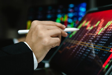 A trader analyzes real-time financial data on multiple devices, tracking stock charts, market trends, and investment strategies to manage risk, maximize profit, and grow a digital portfolio
