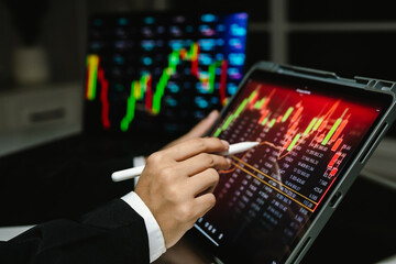 A trader analyzes real-time financial data on multiple devices, tracking stock charts, market trends, and investment strategies to manage risk, maximize profit, and grow a digital portfolio
