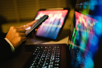 A trader analyzes real-time financial data on multiple devices, tracking stock charts, market trends, and investment strategies to manage risk, maximize profit, and grow a digital portfolio
