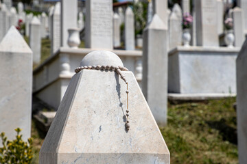 Rosary Beads Adorning a Marble Gravestone in a Peaceful Cemetery, Kovaci Cemetery in Sarajevo.
