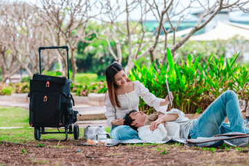 Asian Couple Watching Tablet Outdoors