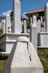 Rosary Beads Adorning a Marble Gravestone in a Peaceful Cemetery, Kovaci Cemetery in Sarajevo.
