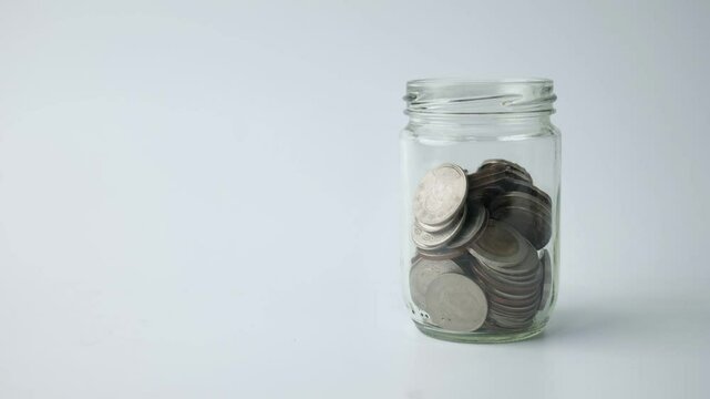 Coins in jar increase and decrease concept, money management investment, stop motion.