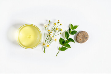 A white surface with a glass of lemonade, a small plant, and a stone.