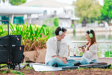 Asian Couple Enjoying Music Outdoors