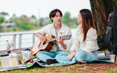 Asian Couple Playing Guitar Outdoors
