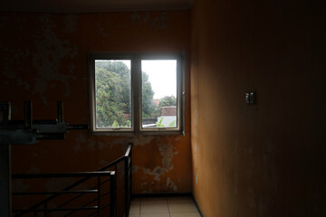 Dimly Lit Stairwell with Peeling Orange Wall
