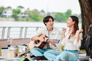 Asian Couple Playing Guitar Outdoors