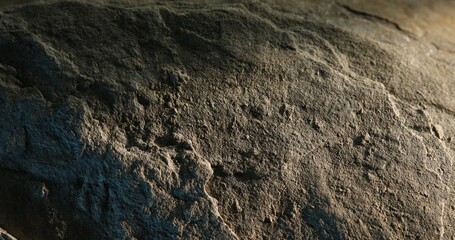 Close-up of weathered rock texture with blue shadow and rough surface detail
