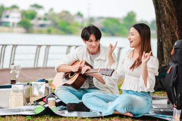 Asian Couple Playing Guitar Outdoors