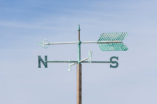 old weather vane against blue sky