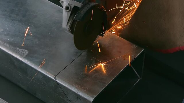 skilled worker cutting an iron pipe with a grinder video with sound