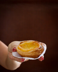 mão feminina segurando pastel de Belém