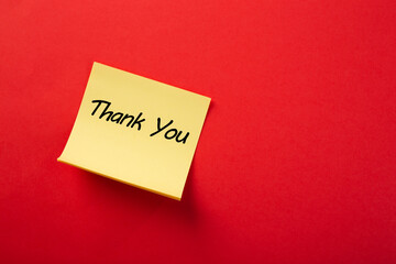 Yellow sticky note showing thank you on red background