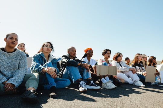 Diverse group of young adults sitting down during a protest