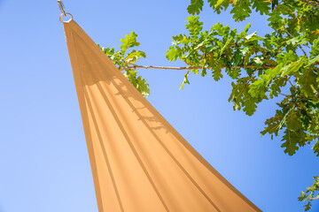 Detail of sun shade sail or awnings against sunny blue sky for balcony or patio