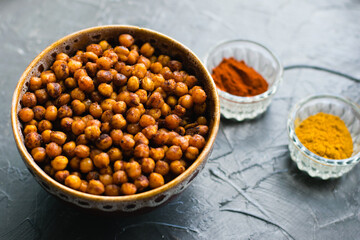 Delicious snack, fragrant baked with curry spices and smoked paprika chickpeas in a brown bowl and...