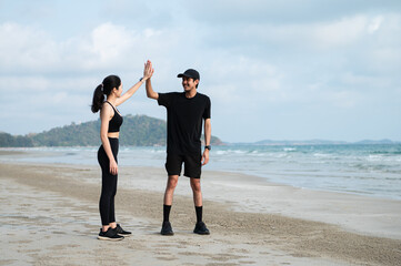 Young men and women run along the sea or beach to promote health, strength and quality of life,...
