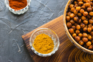 Delicious snack, fragrant baked with curry spices and smoked paprika chickpeas in a brown bowl and...