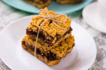 Delicious homemade pie with apple jam. Appetizing slices of grated pie with jam on a white plate on a light table