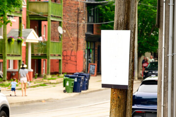 Wooden utility pole with blank white posted poster board surrounded by thousands of staples from...