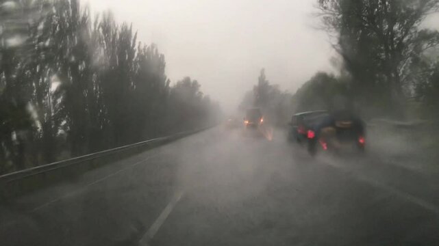 Driving in heavy rain. Driver's point of view of driving on rural road in rainstorm. 