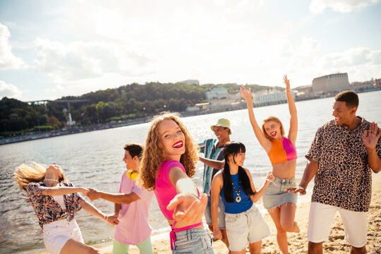 Group of cheerful friends enjoying time together at the beach, celebrating summer in an urban outdoor setting