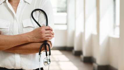 Healthcare Professional Holding a Stethoscope in a Bright Corridor Setting
