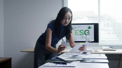 Professional female financial analyst reviewing sustainability strategy documentation, evaluating environmental and corporate governance data at modern workspace - Powered by Adobe
