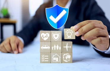 Insurance concept with businessman arranging a wooden dice about health asset and life insurance to...