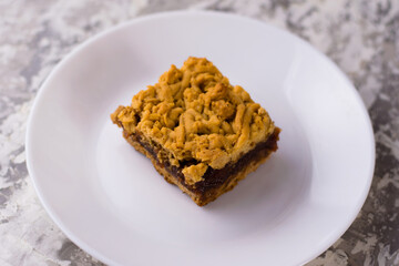 Delicious homemade pie with apple jam. A crispy piece of grated pie with jam on a plate, the aroma of apple and cinnamon