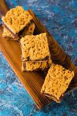 Delicious homemade pie with apple jam. Crispy pieces of grated pie with jam on a wooden board close-up, apple and cinnamon aroma