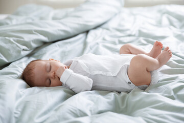 Cute sweet newborn baby sleeping on bed